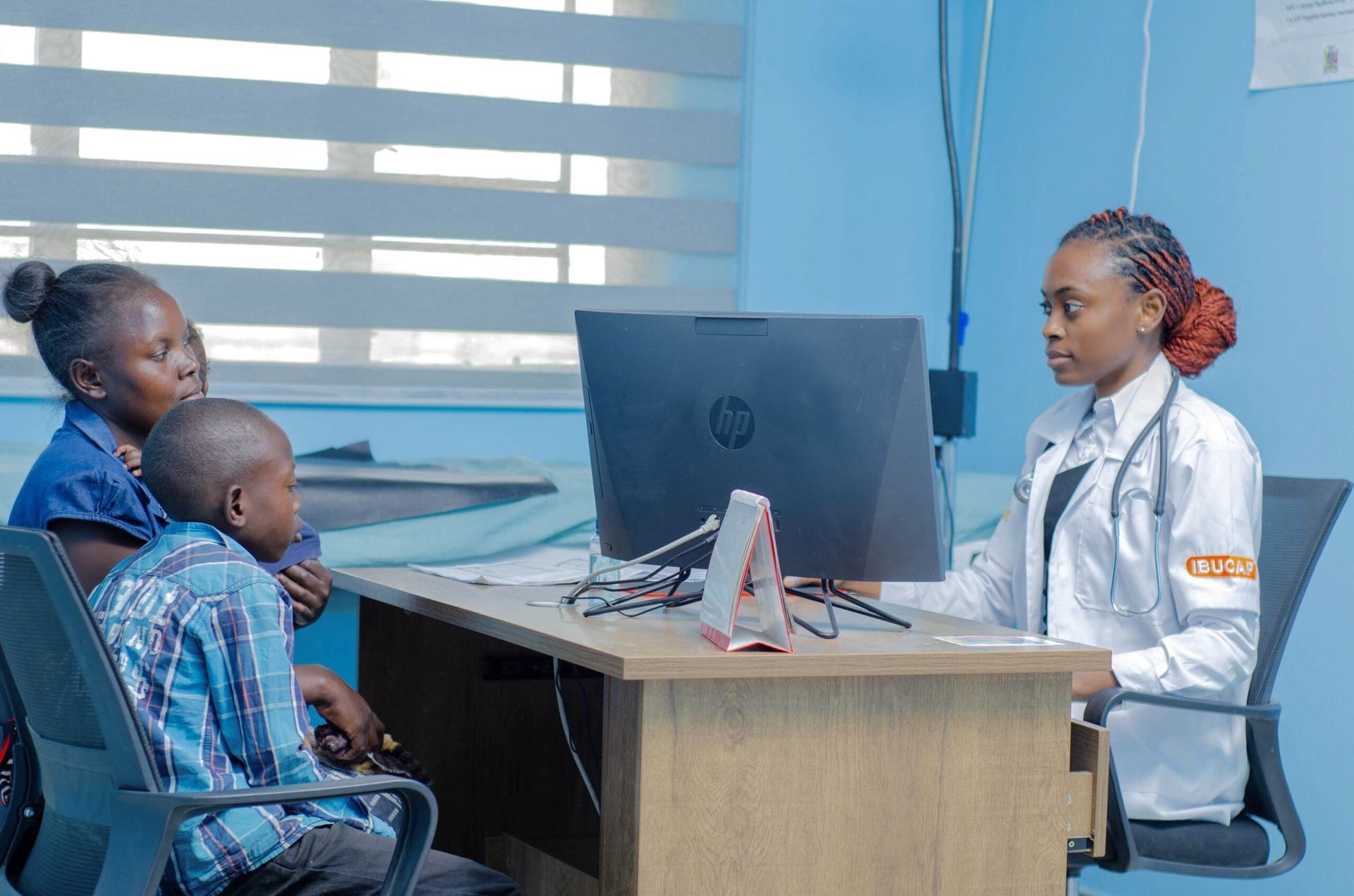 A clinician at Anthu Omwe Health Center consulting with a mother and child
